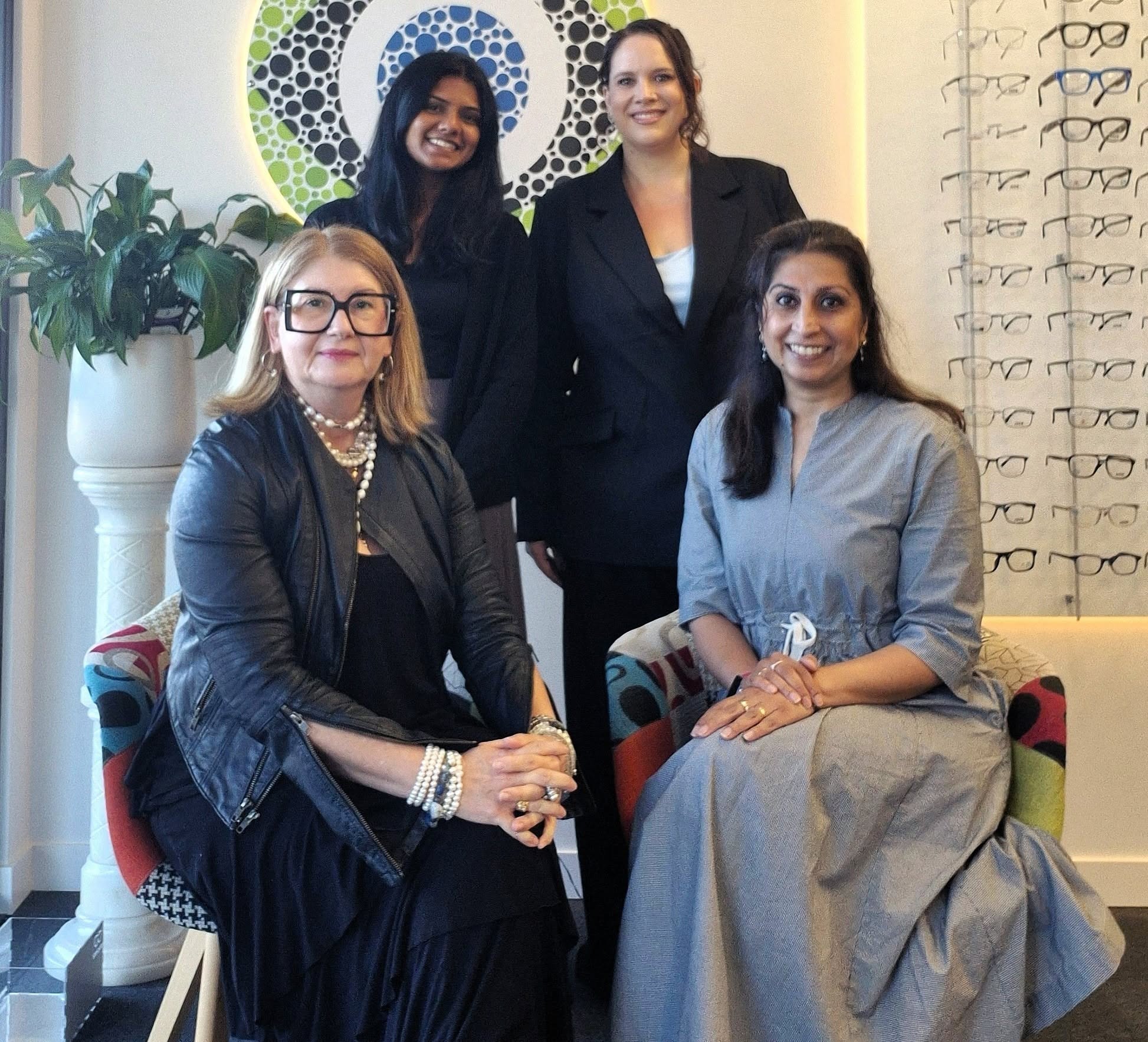 The Mortdale Eyecare team in the practice beneath the logo mural